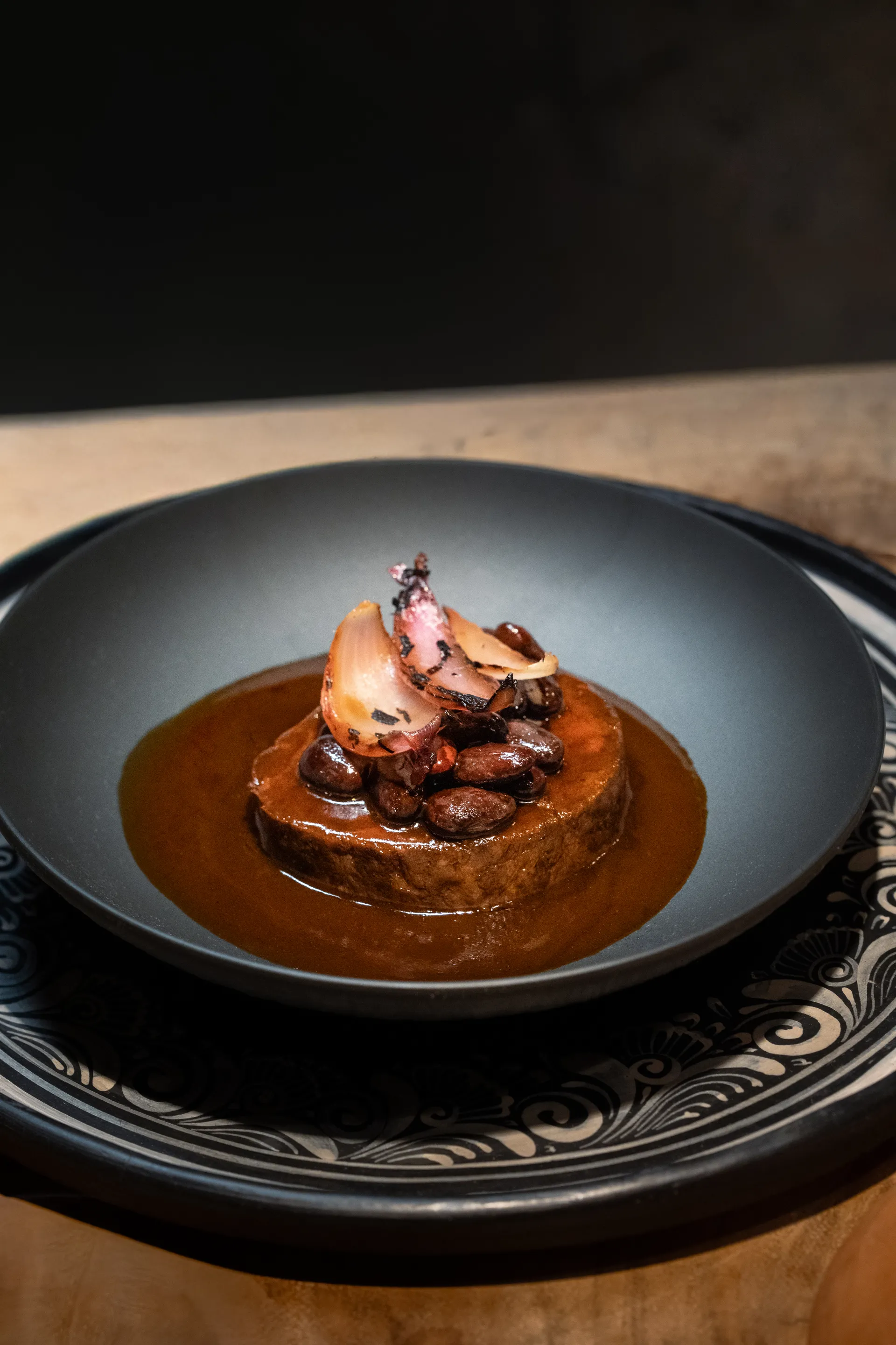Premier course plated in a dark sauce at Rhythms of the Night